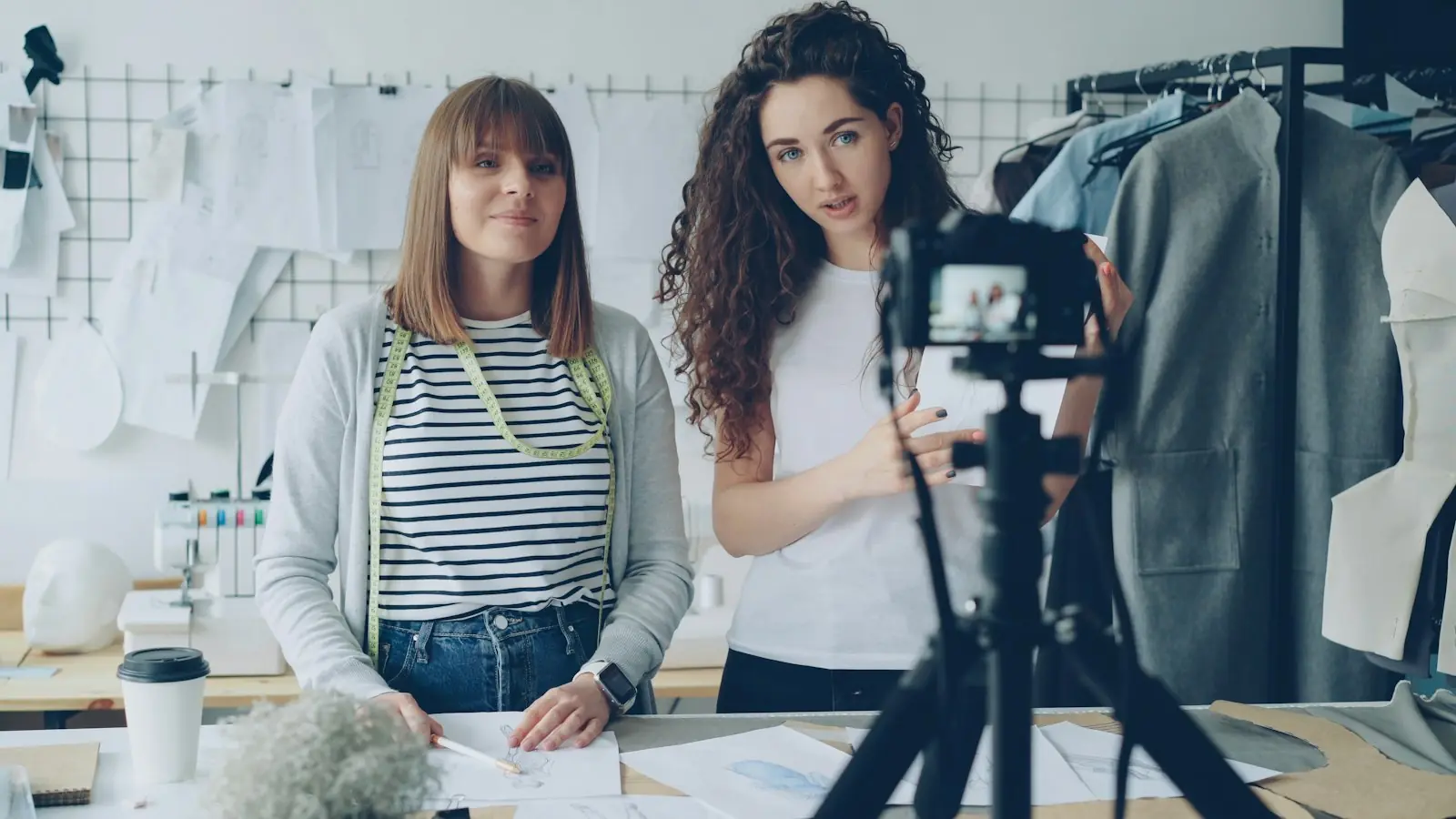 Duas apresentadoras gravando com câmera no tripé
